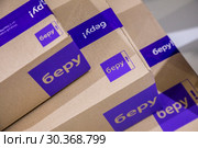 Крупным планом упаковка онлайн  маркетплейса "Беру!", являющийся совместным предприятием "Сбербанка" и "Яндекса" на выставке (2019 год). Редакционное фото, фотограф Николай Винокуров / Фотобанк Лори
