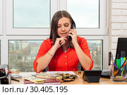Перед девушкой в офисе на столе лежат деньги, девушка разговаривает по телефону. Стоковое фото, фотограф Иванов Алексей / Фотобанк Лори