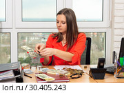 Девушка в офисе кладет деньги в продуктовую тележку. Стоковое фото, фотограф Иванов Алексей / Фотобанк Лори