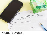 Налоговая декларация по налогу на доходы физических лиц (форма 3-НДФЛ), ручка, смартфон и купюры. Стоковое фото, фотограф Наталья Гармашева / Фотобанк Лори