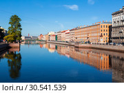 View of the Fontanka river with with English bridge in the distance, profitable houses on the waterfront and their mirror image in the water. Saint Petersburg, Russia (2018 год). Стоковое фото, фотограф Наталья Волкова / Фотобанк Лори