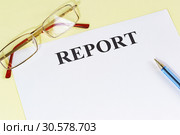 Подготовка отчета о проделанной работе. Очки, ручка и лист бумаги с надписью "Report" на столе. Стоковое фото, фотограф Наталья Гармашева / Фотобанк Лори