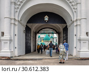 Московская область. Истра. Сентябрь 13, 2017. Надвратная церковь Входа Господня в Иерусалим. Прихожане проходят через ворота к Воскресенскому Ново-Иерусалимскому мужскому монастырю. Редакционное фото, фотограф Светлана Васильева / Фотобанк Лори