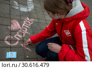 Болельщица футбольного клуба Спартак рисует мелками на площади перед стадионом в городе Москве в день рождения , Россия (2019 год). Редакционное фото, фотограф Николай Винокуров / Фотобанк Лори