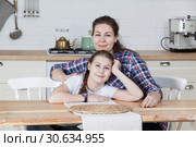 Мама с дочкой на кухне сидят за столом. Стоковое фото, фотограф Кекяляйнен Андрей / Фотобанк Лори