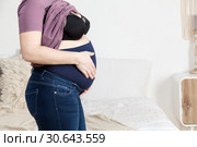 Специальные брюки для беременных с резинкой для поддержки живота, женщина в спальне. Стоковое фото, фотограф Кекяляйнен Андрей / Фотобанк Лори
