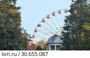 Ferris wheel rotates in a park in the foreground roof observatory. Стоковое фото, фотограф Uladzimir Sitkouski / Фотобанк Лори