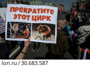 Участник Марша в защиту животных в городе Москве держит плакат с требованием запретить использование животных в цирковых номерах, Россия, 1 мая 2019. Редакционное фото, фотограф Николай Винокуров / Фотобанк Лори