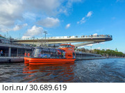 Москва. Вид с реки на парящий мост с туристами в парке «Зарядье» и прогулочный теплоход "Астра" с туристами на причале (2019 год). Редакционное фото, фотограф Татьяна Белова / Фотобанк Лори