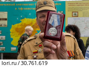 Ветераны Афганской войны держат в руках медаль "30 лет завершения выполнения задач 40 армией в Афганистане" на фоне карты Афганистана в Севастополе, 19 мая 2019 года. Редакционное фото, фотограф Николай Винокуров / Фотобанк Лори