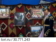 Участница фольклорного ансамбля в национальной одежде на фоне старинных крымских пейзажей во время празднования крымско-татарского праздника Хедерлез в в городе Бахчисарай, Республика Крым (2019 год). Редакционное фото, фотограф Николай Винокуров / Фотобанк Лори