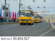 Колонна желтых автобусов Икарус на Дворцовом мосту. Фрагмент парада ретро транспорта в честь Дня города. Санкт-Петербург. Редакционное фото, фотограф Виктор Карасев / Фотобанк Лори