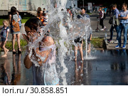 Девушка купается струе вода на пешеходном фонтане около Москвариума во время изнуряющей жары в городе Москве, Россия (2019 год). Редакционное фото, фотограф Николай Винокуров / Фотобанк Лори