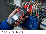 Electrician work concept. Hand with multimeter tester in switchbox. Стоковое фото, фотограф Дмитрий Калиновский / Фотобанк Лори