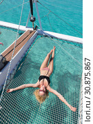 Woman relaxing on a summer sailing cruise,lying in hammock of luxury catamaran near picture perfect white sandy beach on Spargi island in Maddalena Archipelago, Sardinia, Italy. Стоковое фото, фотограф Matej Kastelic / Фотобанк Лори