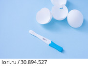 Infertility. Negative pregnancy test and eggshell on blue. Стоковое фото, фотограф Papoyan Irina / Фотобанк Лори