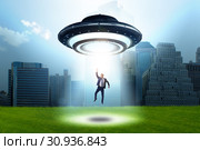 Flying saucer abducting young businessman. Стоковое фото, фотограф Elnur / Фотобанк Лори