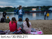 Зрители во время просмотра на экране короткометражных фильмов в рамках фестиваля уличного кино "Кино на воде" в городе Тутаеве, Ярославская область, Россия (2019 год). Редакционное фото, фотограф Николай Винокуров / Фотобанк Лори