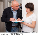 Collector is trying to get the arrears from woman at home door. Стоковое фото, фотограф Яков Филимонов / Фотобанк Лори