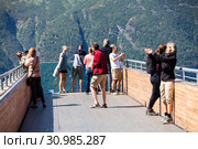 Tourists enjoy fjord view Aurlandsfjord landscape from Stegastein viewing point. Aurlandsfjellet. Norway (2018 год). Редакционное фото, фотограф Кекяляйнен Андрей / Фотобанк Лори