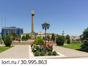 Цветник около стелы с гербом России в честь присвоения городу звания "Город воинской славы" перед зданием мэрии Грозного (2019 год). Редакционное фото, фотограф Наталья Гармашева / Фотобанк Лори