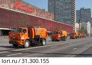 Москва, Новый Арбат. Уборка улицы после прохождения парадной колонны военной техники. Колонна оранжевых грузовиков-уборщиков с праздничной георгиевской лентой на капоте вытянулась вдоль улицы (2019 год). Редакционное фото, фотограф Наталья Николаева / Фотобанк Лори