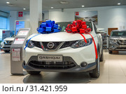 Проданный автомобиль "Nissan-Кашкай" (2019) с двумя бантами красного и синего цвета в автосалоне официального дилера. Редакционное фото, фотограф Виктор Карасев / Фотобанк Лори