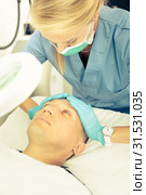 Woman doctor is massaging face of patient after the procedure. Стоковое фото, фотограф Яков Филимонов / Фотобанк Лори