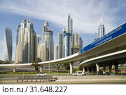 DUBAI, UAE, JANUARY 13, 2019: Road of new waterfront destination at Palm Jumeirah on the background of modern beautiful high-rise buildings. Редакционное фото, фотограф Олег Белов / Фотобанк Лори