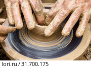 Potter’s fingers touch the shapeless piece of clay on the rotating wheel. Стоковое фото, фотограф Евгений Харитонов / Фотобанк Лори