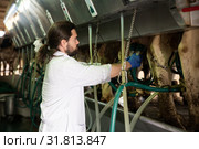 Dairymaid young man working with automatical cow milking machines. Стоковое фото, фотограф Яков Филимонов / Фотобанк Лори