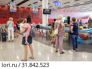Пассажиры ждут  выдачу багажа у багажной ленты, аэропорт Бургас, Болгария (2019 год). Редакционное фото, фотограф Юлия Бабкина / Фотобанк Лори