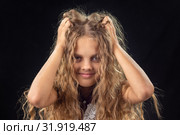 Десятилетняя девочка лохматит руками длинными русыми волосами. Стоковое фото, фотограф Иванов Алексей / Фотобанк Лори