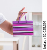 Young man with gift bag at home preparing suprise for wife. Стоковое фото, фотограф Elnur / Фотобанк Лори