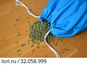 Green mung bean in blue reusable package on wooden background. Eco packaging concept. Стоковое фото, фотограф Ольга Балынская / Фотобанк Лори