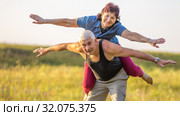 Happy mature woman climbed on her husband in the park on a summer sunny day. Стоковое фото, фотограф Акиньшин Владимир / Фотобанк Лори