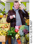 Man talking on mobile phone in greengrocery. Стоковое фото, фотограф Яков Филимонов / Фотобанк Лори