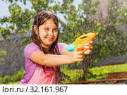 Determined girl in fun water gun fight game. Стоковое фото, фотограф Сергей Новиков / Фотобанк Лори