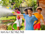 Boy and friends in water gun fight active fun game. Стоковое фото, фотограф Сергей Новиков / Фотобанк Лори