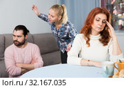 Husband and wife quarrelling indoors, senior mother taking it hard. Стоковое фото, фотограф Яков Филимонов / Фотобанк Лори