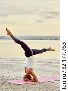 Yogi woman practising yoga outdoors doing Salamba Sirsasana asana. Стоковое фото, фотограф Alexander Tihonovs / Фотобанк Лори