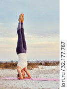 Woman doing Hatha yoga headstand or Sirsasana outdoors. Стоковое фото, фотограф Alexander Tihonovs / Фотобанк Лори