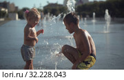 Siblings play with a fountain. Стоковое видео, видеограф Данил Руденко / Фотобанк Лори