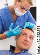 Female doctor is doing injection to patient in skin of face. Стоковое фото, фотограф Яков Филимонов / Фотобанк Лори