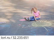 little girl draws with chalk on pavement. Стоковое фото, фотограф Майя Крученкова / Фотобанк Лори