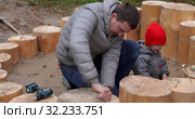 Father and son building stepping stumps circle. Стоковое видео, видеограф Ekaterina Demidova / Фотобанк Лори