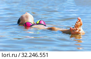 A young woman lies on the surface of a salt lake, a procedure, a treatment. (2016 год). Редакционное фото, фотограф Акиньшин Владимир / Фотобанк Лори