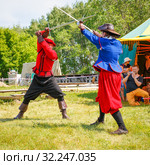 Russia, Samara, June 2016: A battle of musketeers on swords for the audience of the festival "Journey to the Past", which takes place near Samara on a sunny summer day. Редакционное фото, фотограф Акиньшин Владимир / Фотобанк Лори