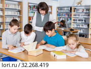Female librarian and schoolkids during classes in library. Стоковое фото, фотограф Яков Филимонов / Фотобанк Лори