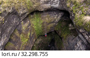 Карстовая пещера Кутук-Сумган. Спуск спелеологов в пещеру. Sumgan-Kutuk karst cave. Descent cavers in the cave. Aerial view. Стоковое видео, видеограф Евгений Романов / Фотобанк Лори